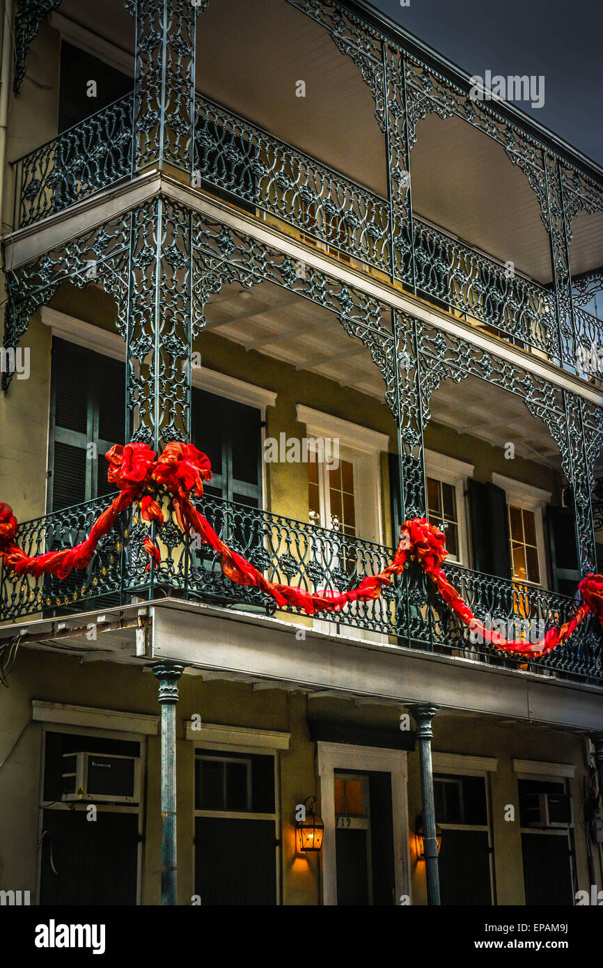 Le velours rouge Maison de festons pendent à la riche en fer forgé créole français, French Quarter, New Orleans, LA Banque D'Images