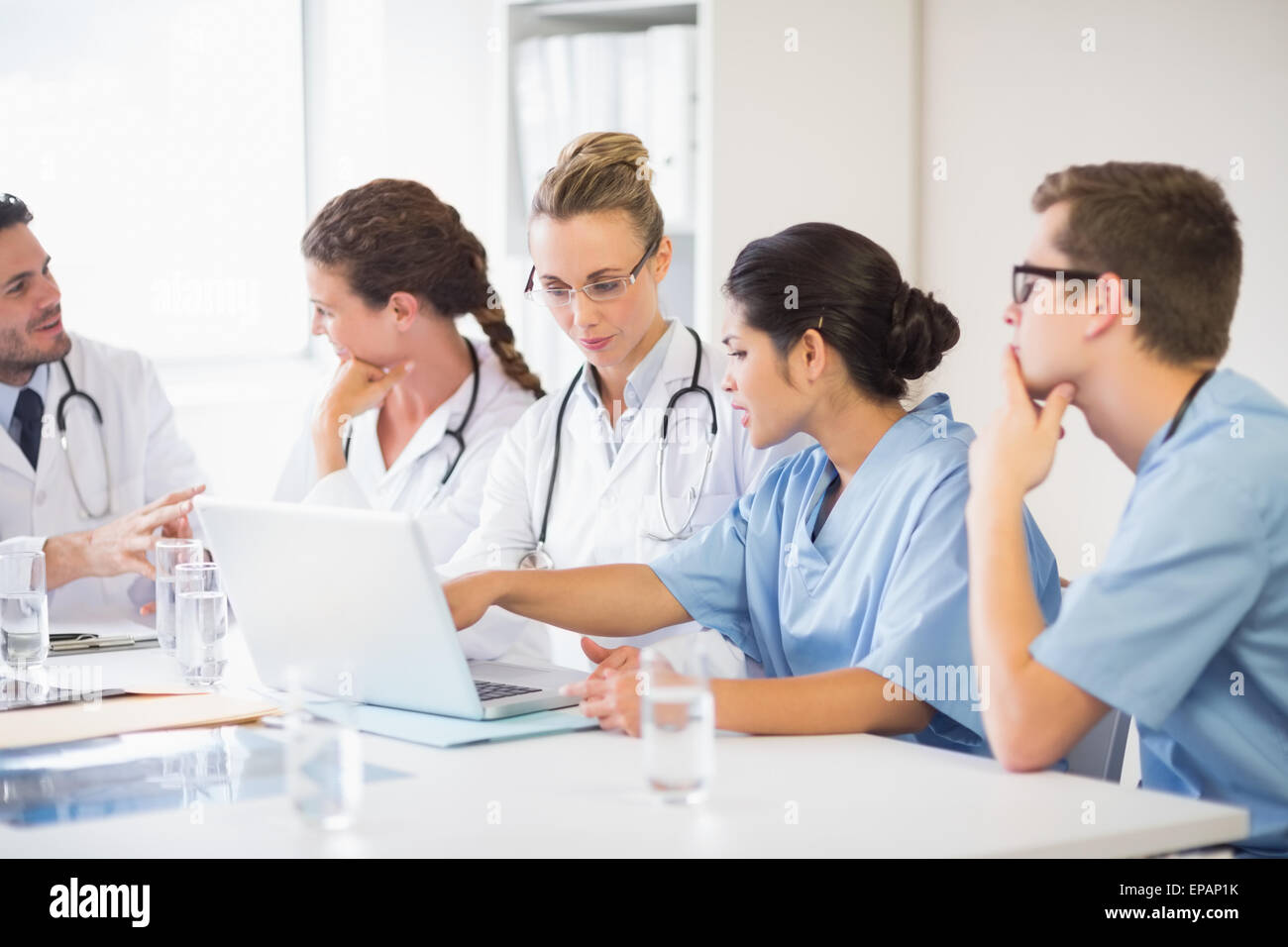 Doctor and nurse discussing over laptop Banque D'Images