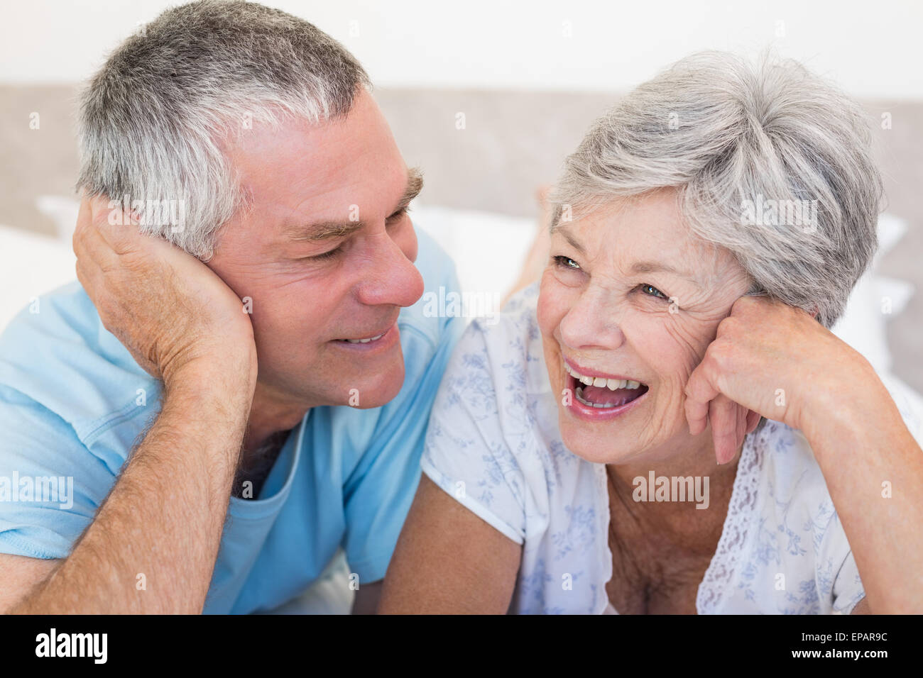 Happy senior couple lying on bed Banque D'Images