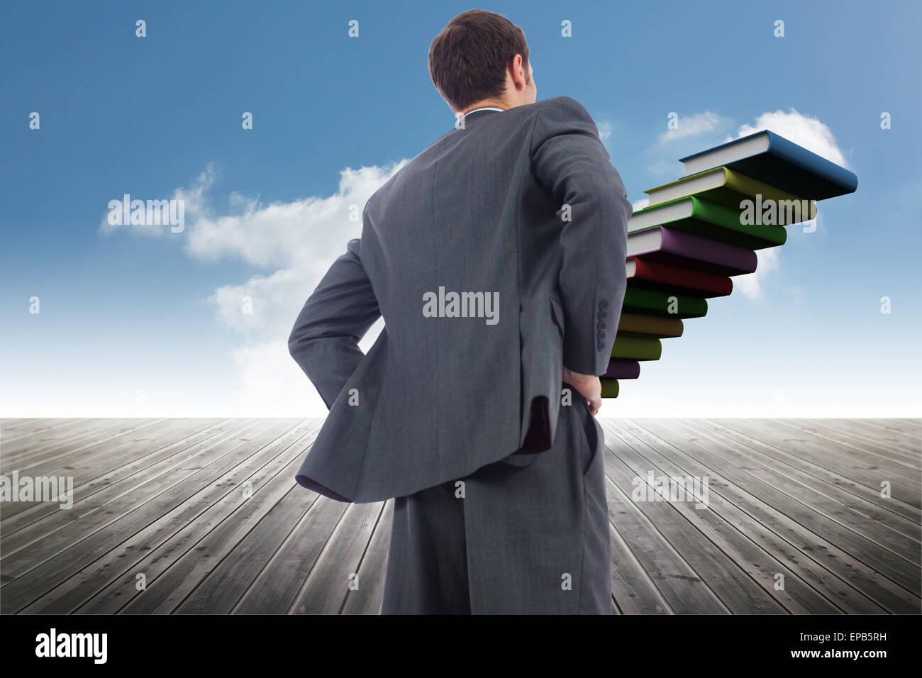 Image composite de businessman standing with hands on hips Banque D'Images