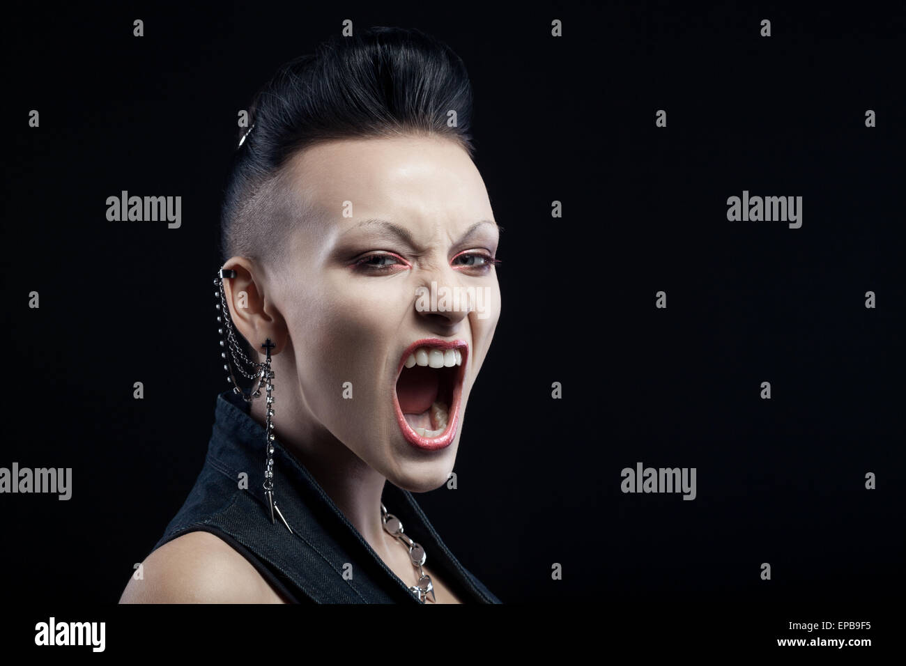 Angry young woman isolated on black Banque D'Images