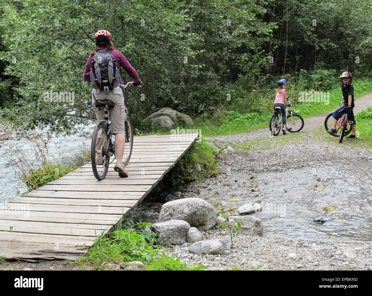Circuit à vélo en famille sur un pont en bois. Comprend une mère et deux enfants Banque D'Images