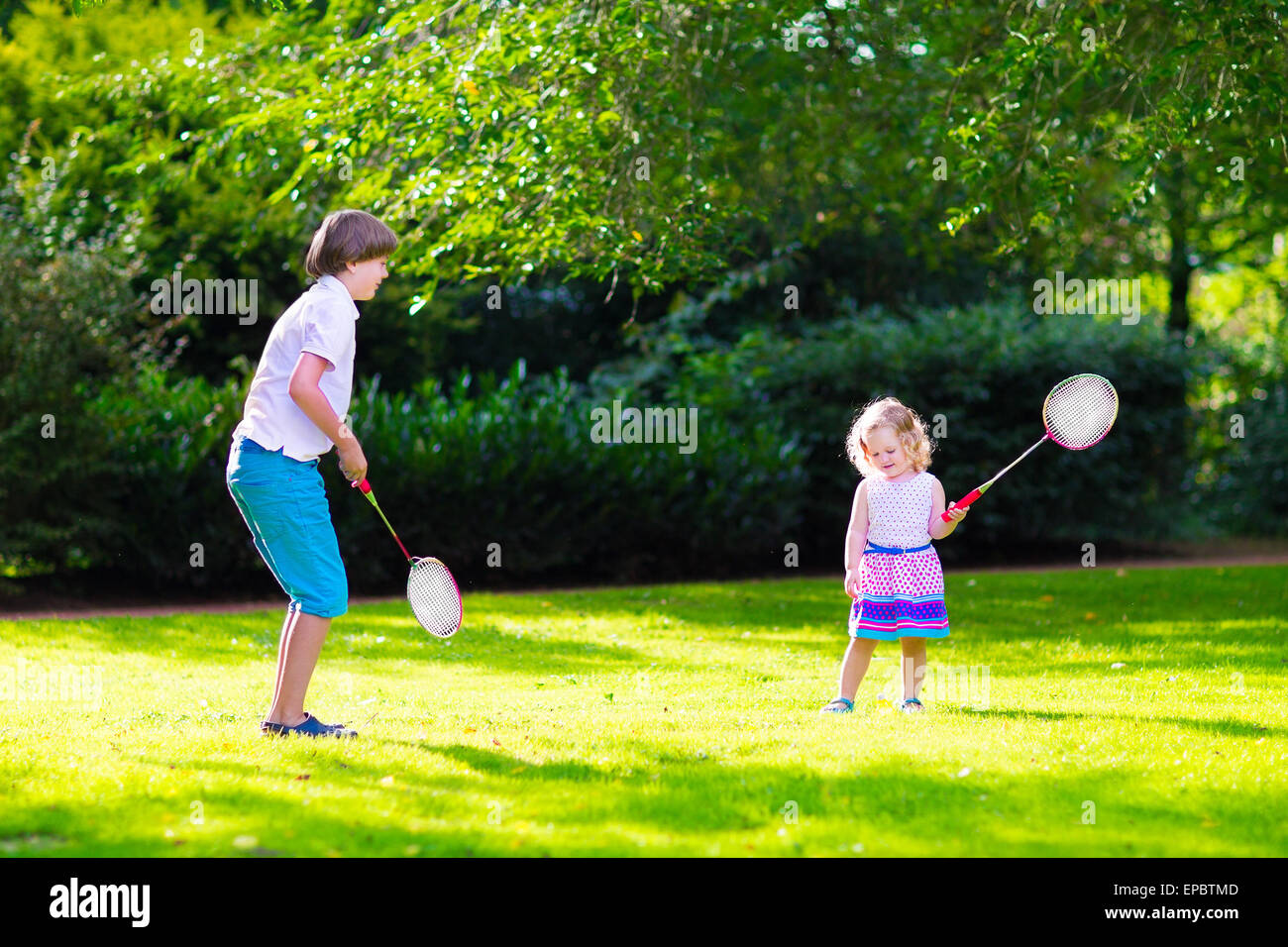 Enfants actifs jouer au badminton. Deux enfants heureux profiter de jeux de  sports, courir et sauter avec raquette de tennis Photo Stock - Alamy