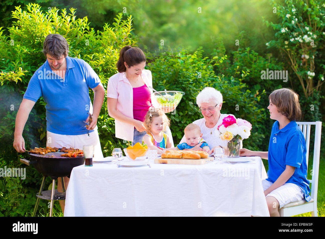 Grill barbecue arrière cour. Heureux big family enjoying barbecue avec grand-mère manger des grillades dans le jardin Banque D'Images