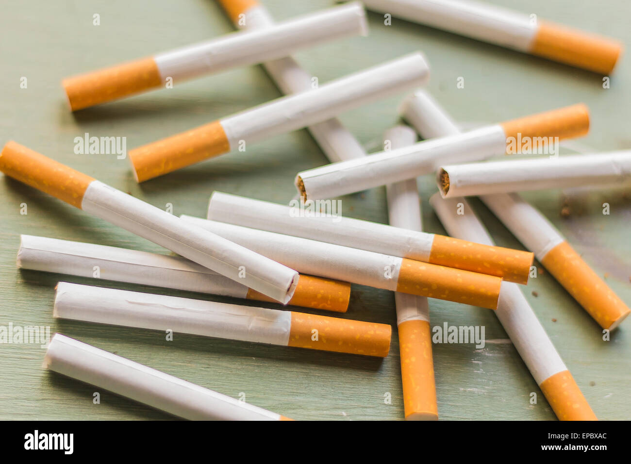 Arrangement de la cigarette sur la surface du bois vert grungy, contexte de l'industrie du tabac Banque D'Images