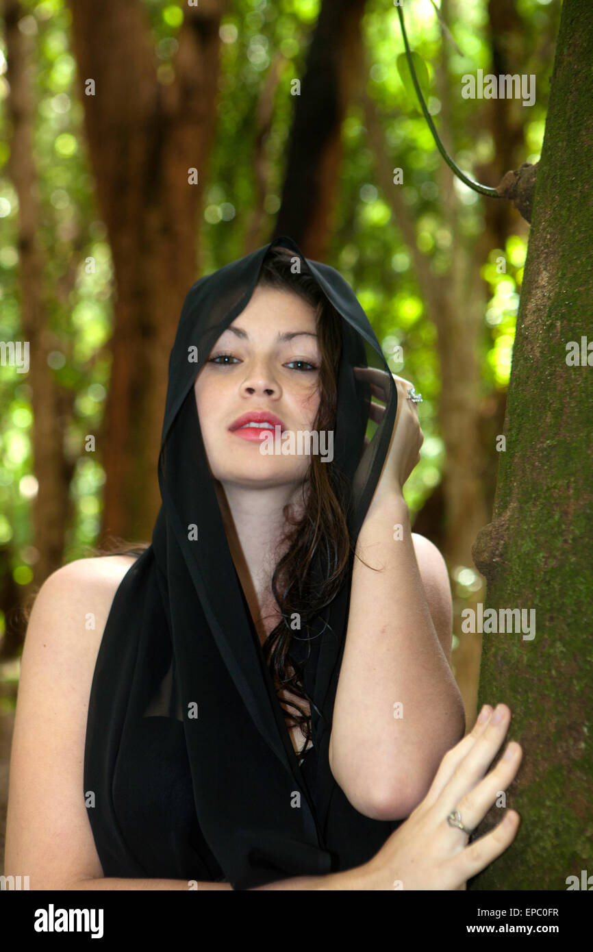 Jeune fille seule dans la forêt en mousseline noire Banque D'Images