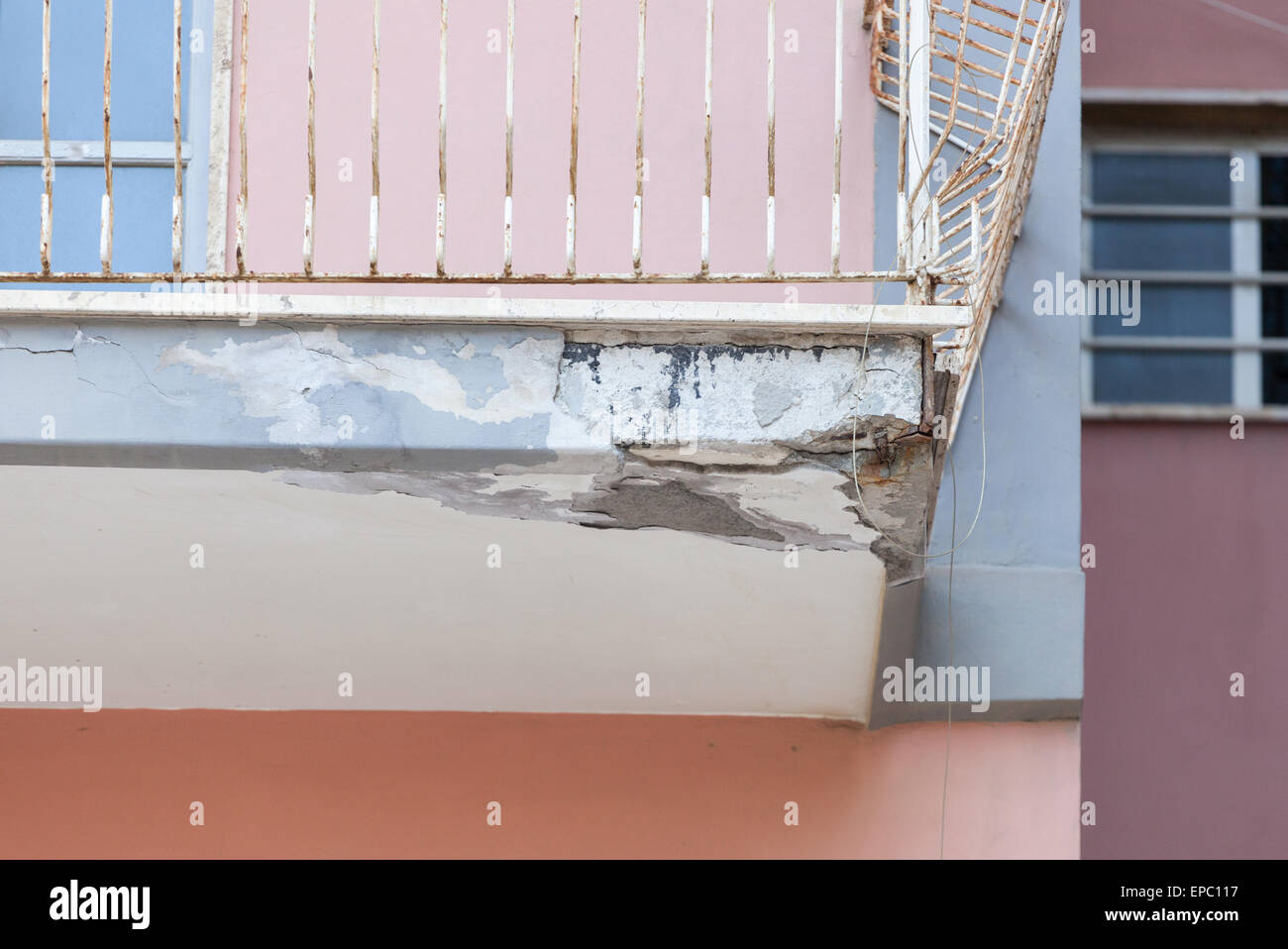 Un balcon avec béton fissuré et un fer rouillé nécessitant une rénovation. Banque D'Images