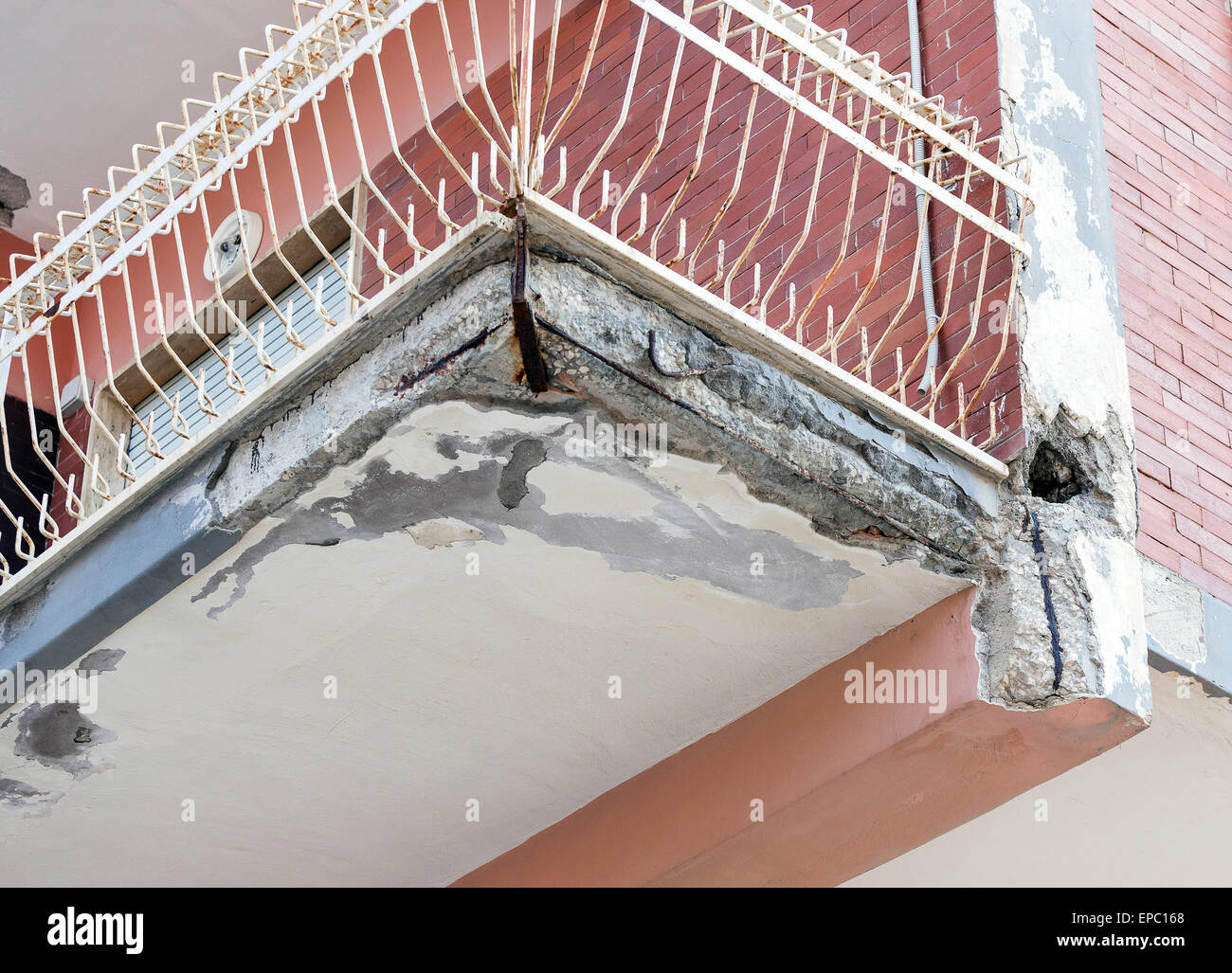 Un balcon avec béton fissuré et un fer rouillé nécessitant une rénovation. Banque D'Images