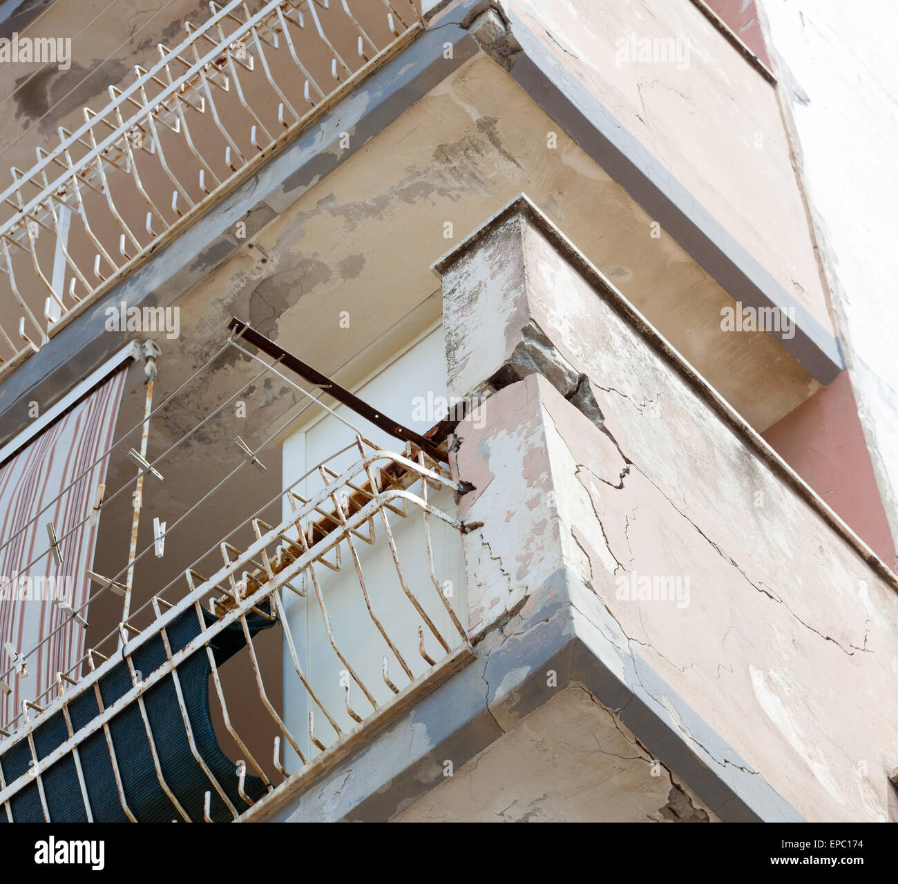 Un balcon avec béton fissuré et un fer rouillé nécessitant une rénovation. Banque D'Images