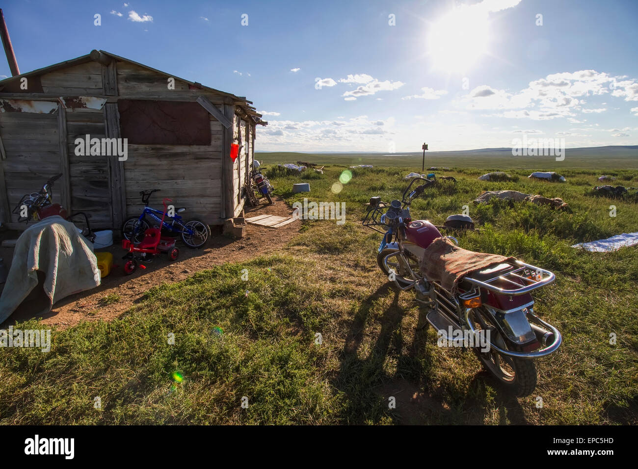 Motorcycle garée à côté d'une maison en bois, Khogno Khan Uul, réserve naturelle de la province Arkhangai, Mongolie Banque D'Images