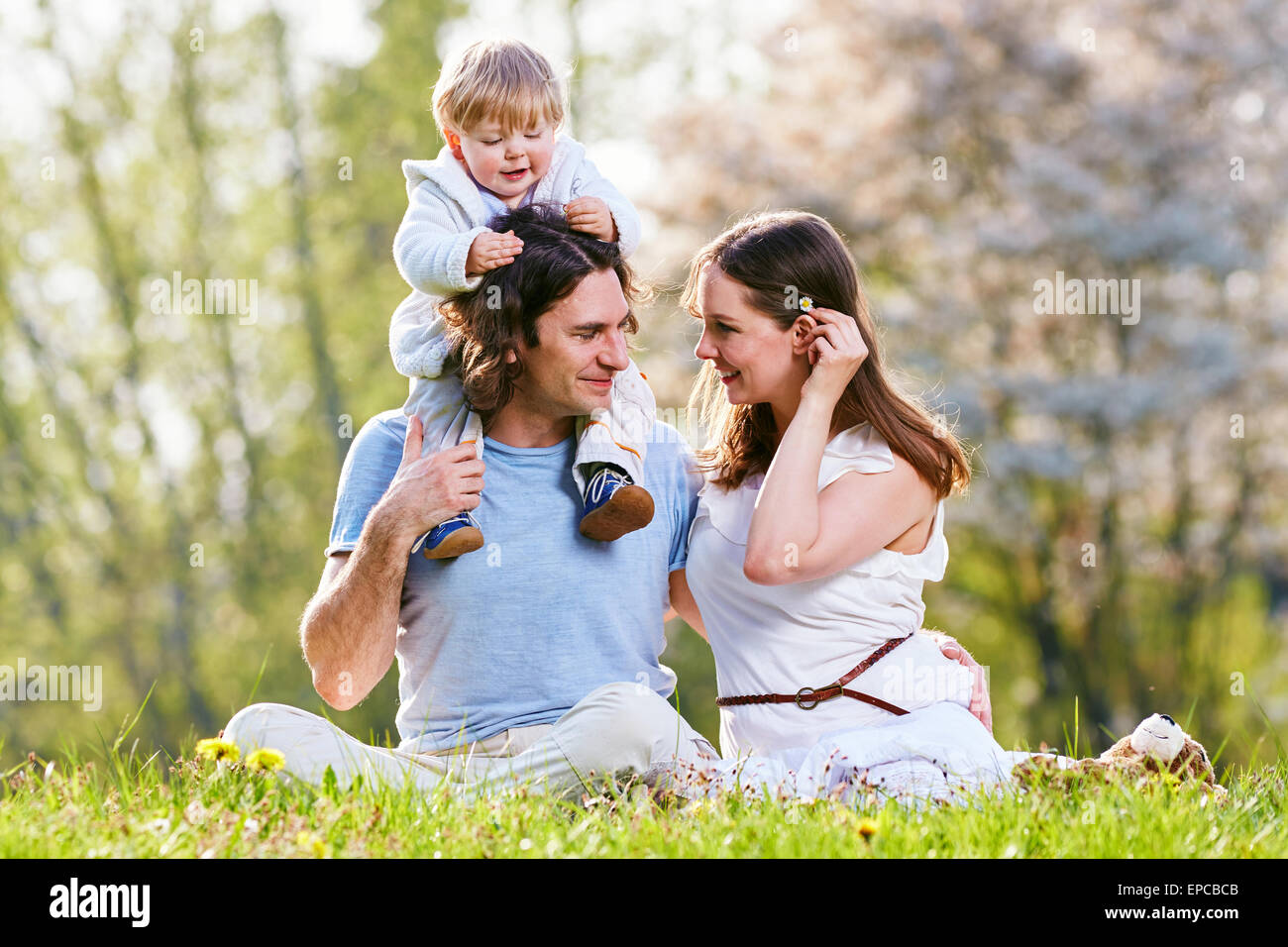 Jeune famille ensemble dans l'herbe sur la prairie Banque D'Images