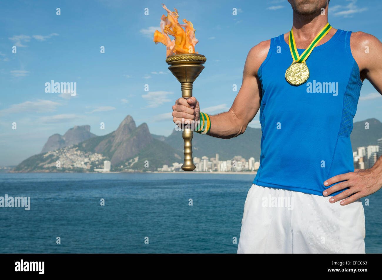 Médaille d'or de l'athlète brésilien avec torche sport permanent au-dessus de Rio de Janeiro Brésil skyline at Ipanema Beach Banque D'Images