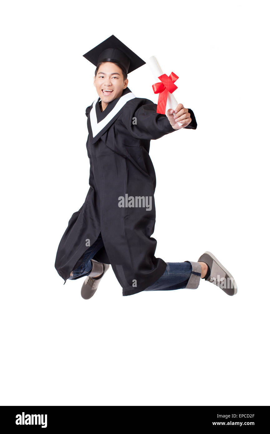 Étudiant diplômé en heureux robe jumping against white background Banque D'Images