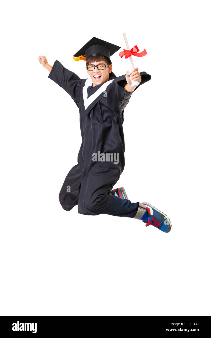 Étudiant diplômé en heureux robe jumping against white background Banque D'Images