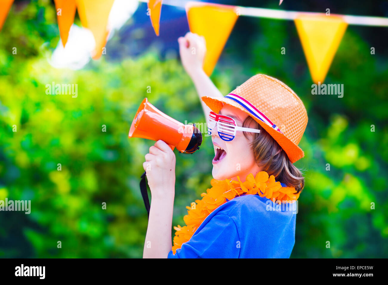 Dutch boy, fan de football, acclamations et soutenir l'équipe de soccer des Pays-Bas au cours de championnat, célébrant la victoire de sport Banque D'Images