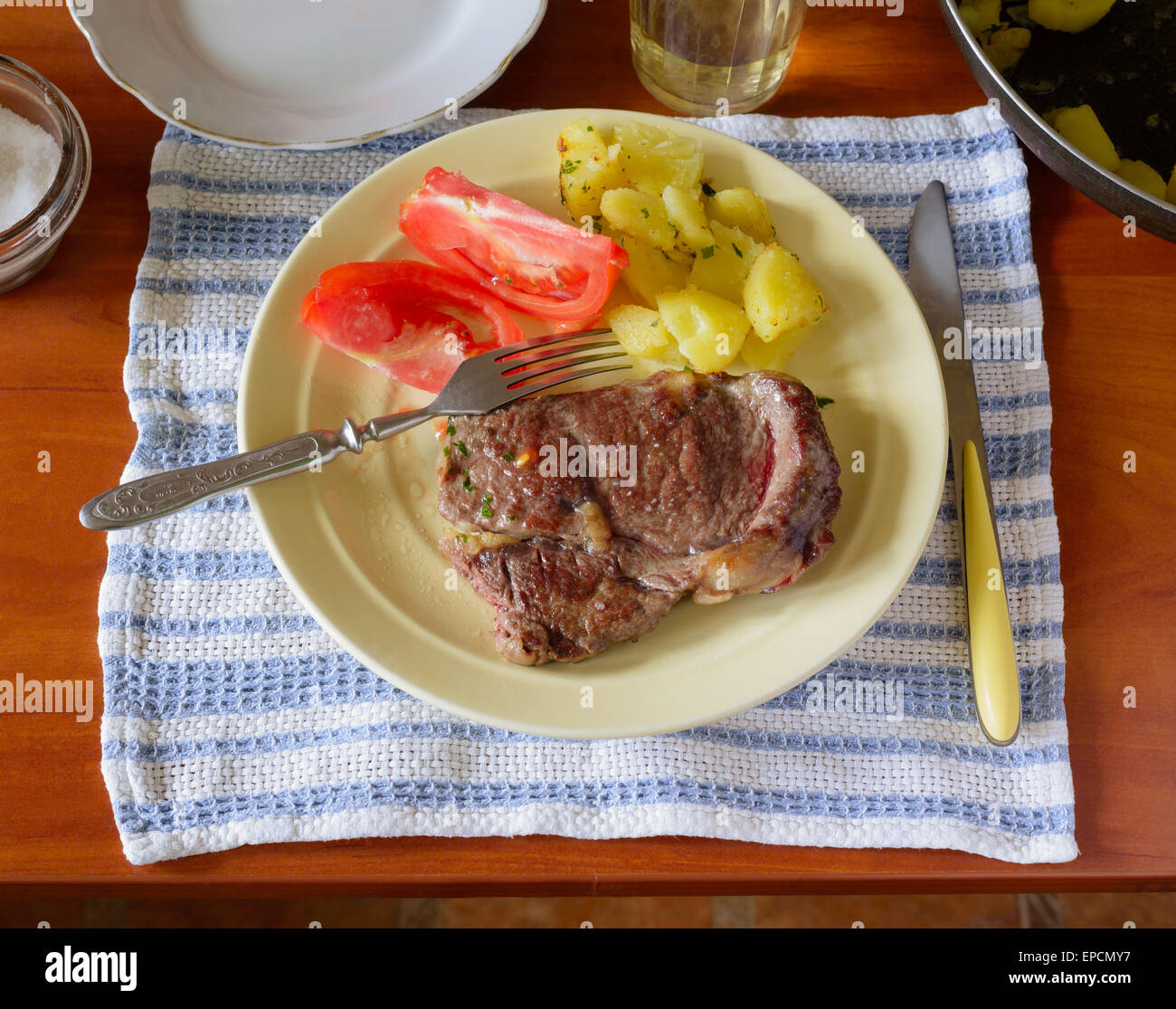 Steak, tomate et pomme de terre pour le déjeuner sur la table de cuisine Banque D'Images