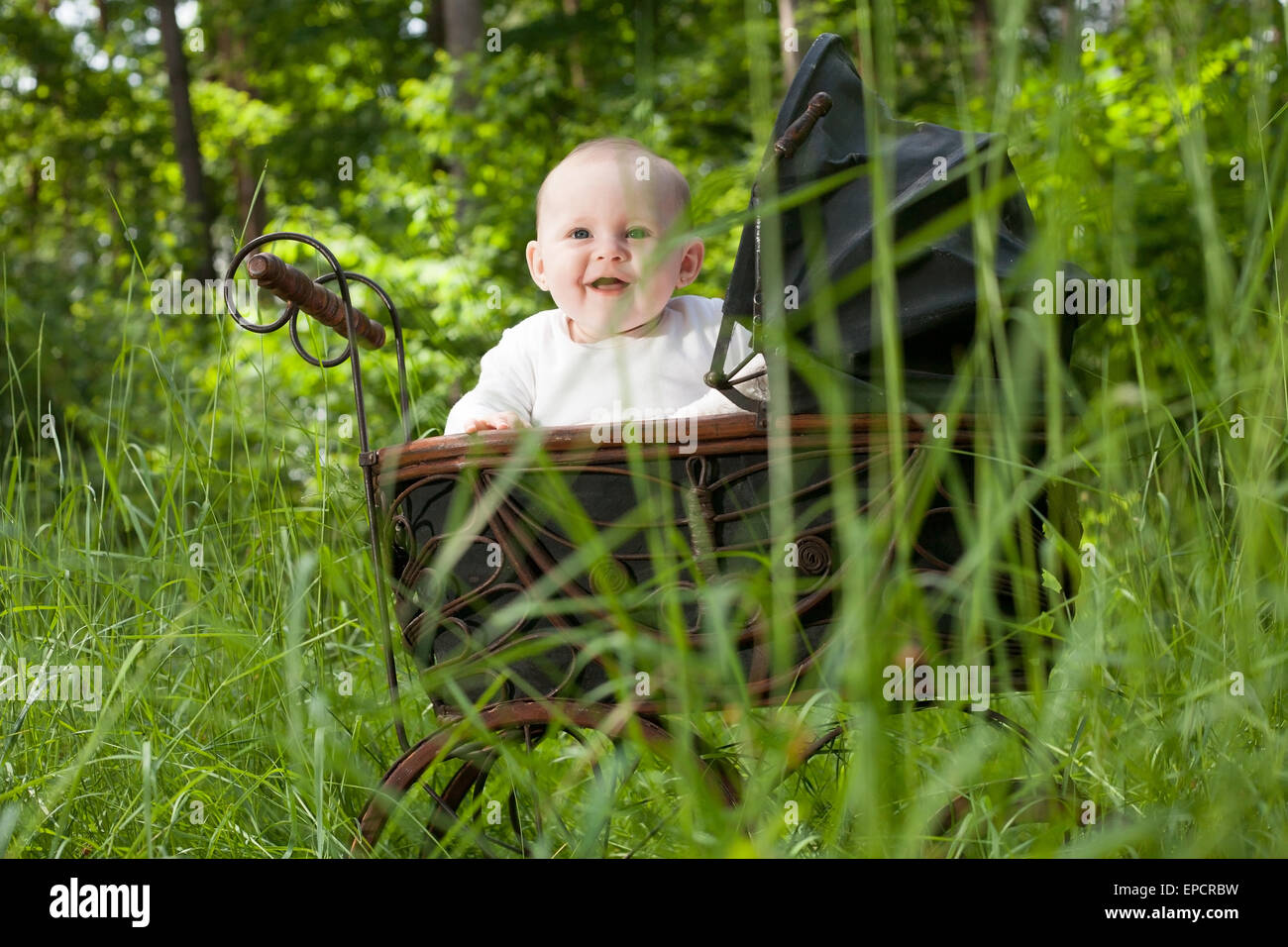 Baby Girl est assis dans un pram vintage Banque D'Images