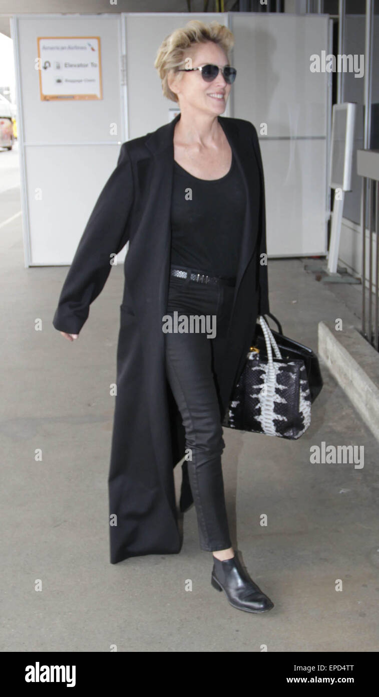 Sharon Stone, vêtus de noir vêtu d'un long manteau style Matrix et tenant  une peau d'alligator noir et blanc sac à main alors qu'elle quitte  l'Aéroport International de Los Angeles (LAX) avec :