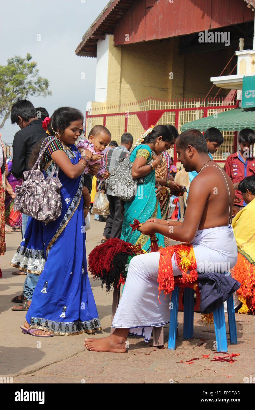 Le temple et la Cité de pèlerinage de Chamundi Hill, Mysore. Un saint homme vend des guirlandes en dehors du temple. Banque D'Images