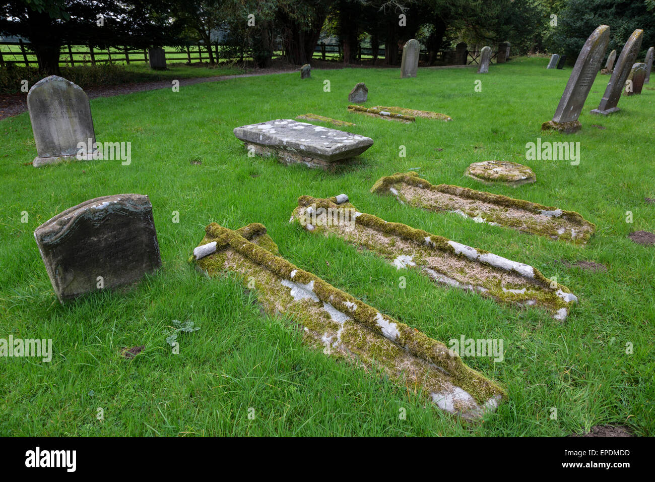 Royaume-uni, Angleterre, dans le Yorkshire. Les pierres tombales dans le cimetière de st oswald's Church, construit autour de 1200 A.D. Banque D'Images