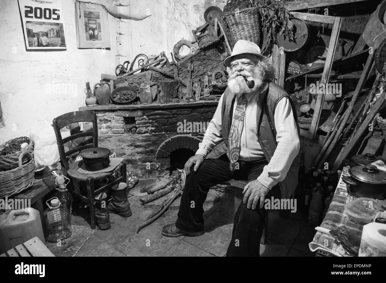 Vieil homme avec une longue barbe blanche fume une pipe Banque D'Images