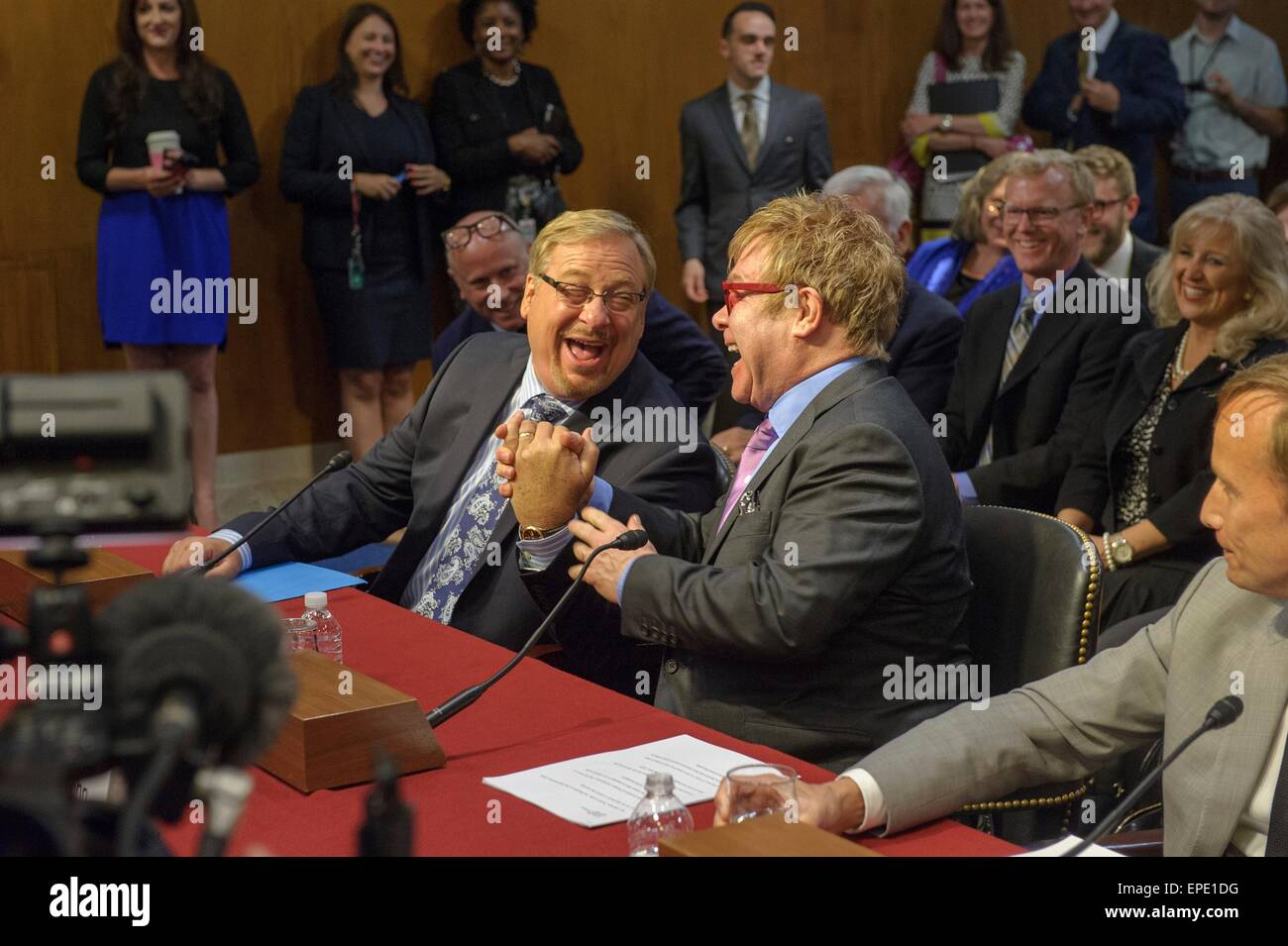 Elton John Singer et pasteur de l'Église Saddleback Rick Warren se serrer la main avant de témoigner devant le Sous-comité des opérations étrangères du Sénat de la commission des affectations budgétaires le 6 mai 2015 à Washington, DC. Les deux ont discuté des questions de santé mondiale. Banque D'Images
