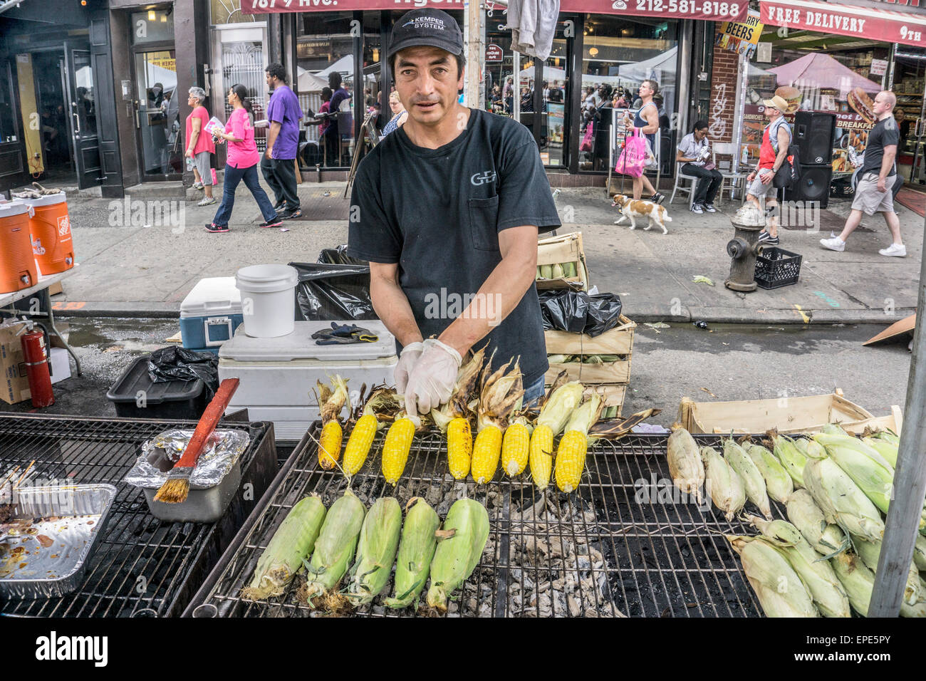 New York, USA. 17 mai, 2015 jeunes & adultes multiethnique. manger des aliments de rue et jouer à l'assemblée annuelle de la 9e Avenue International Food Festival dans le quartier Hell's Kitchen sur fond de Midtown Manhattan. Inauguré en 1973, le festival s'étend à partir de la 57e à la 42e rue, le long de 9e Avenue à New York's Hells Kitchen quartier. Credit : Dorothy Alexander/Alamy Live News Banque D'Images