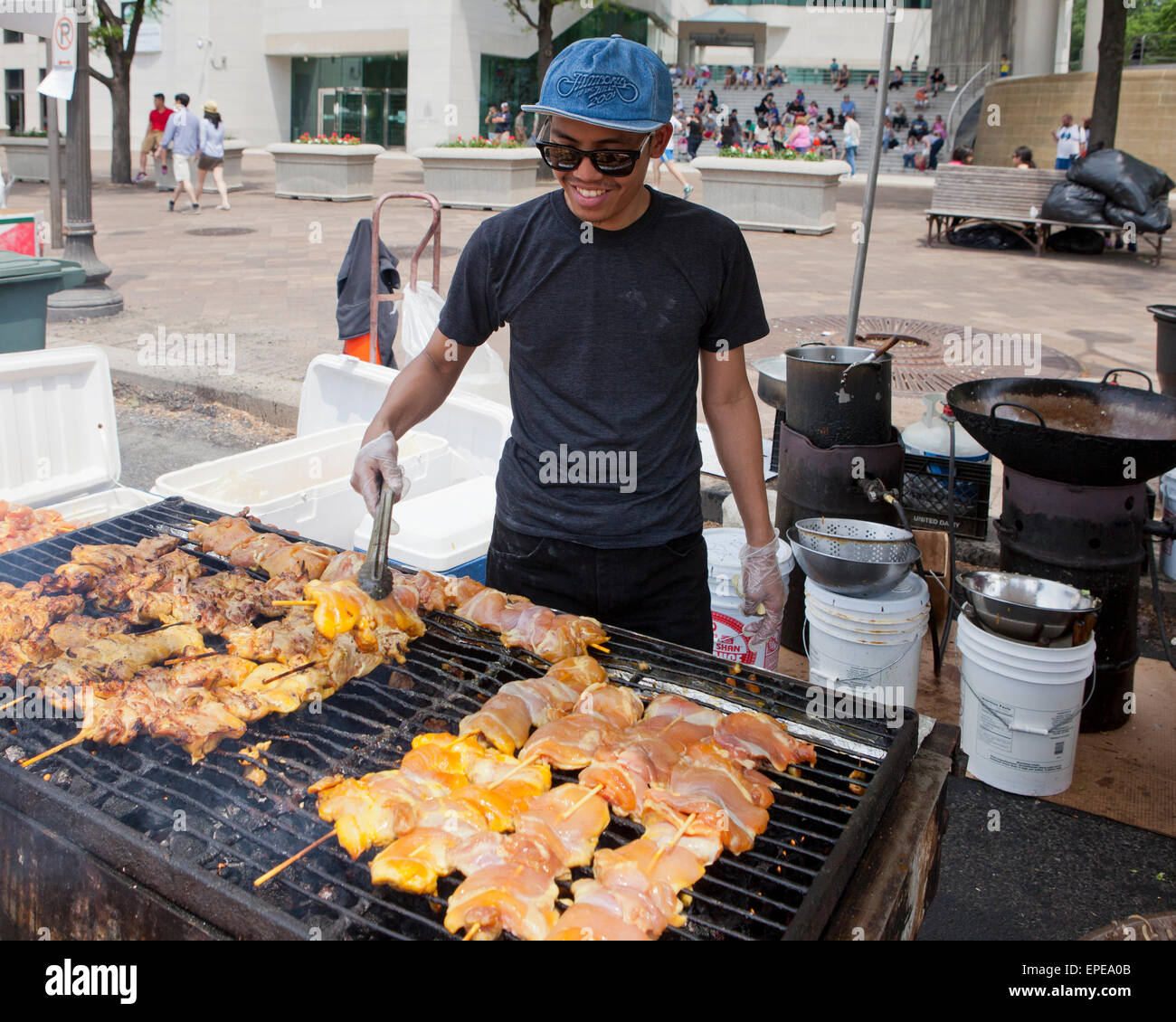 Man grilling barbecue Brochettes de poulet - USA Banque D'Images