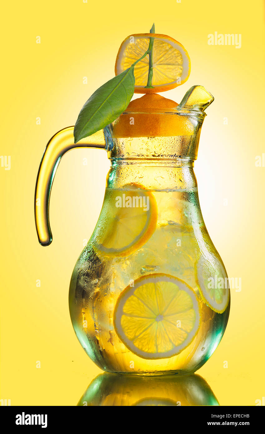 Embuées lemonade pitcher de tranches de citron et des glaçons décoré de jaune citron sur le trimestre Banque D'Images