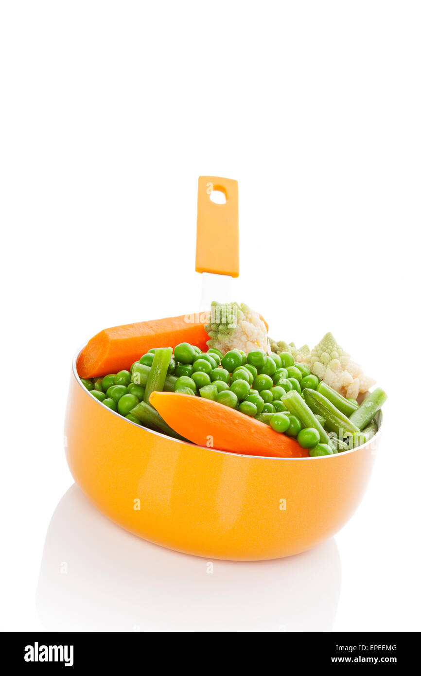 Légumes à la vapeur en pan orange isolé sur fond blanc. La carotte, les haricots verts, les pois verts et le brocoli romanesco. Banque D'Images