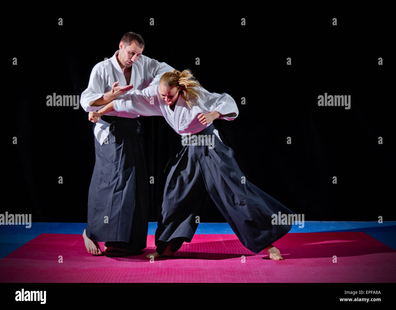 Lutte entre deux combattants d'aikido sur noir Banque D'Images