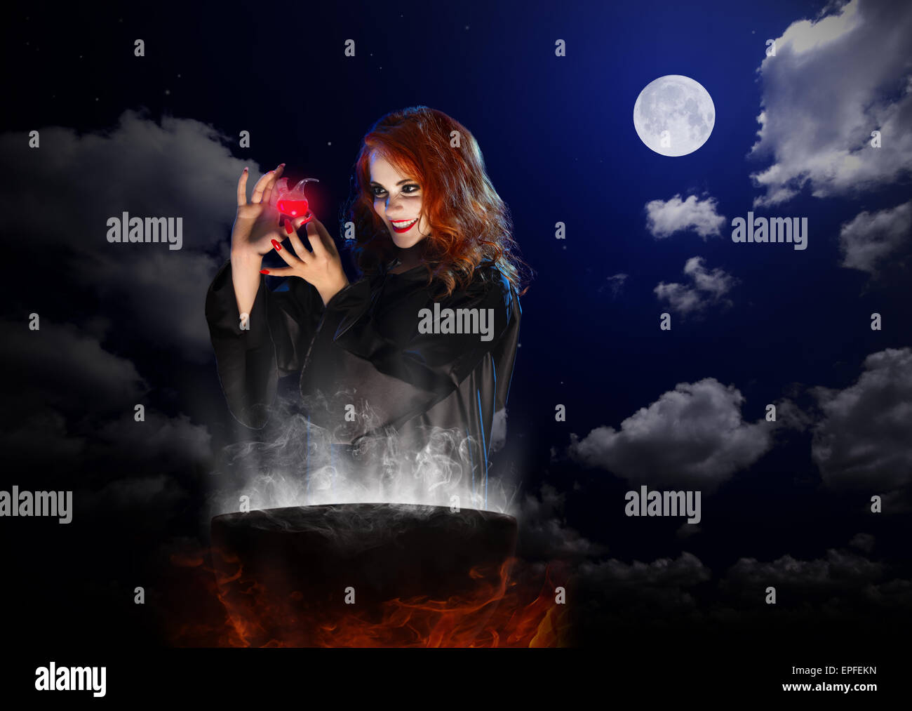 Jeune sorcière avec red potion et chaudron sur fond de ciel de nuit Banque D'Images