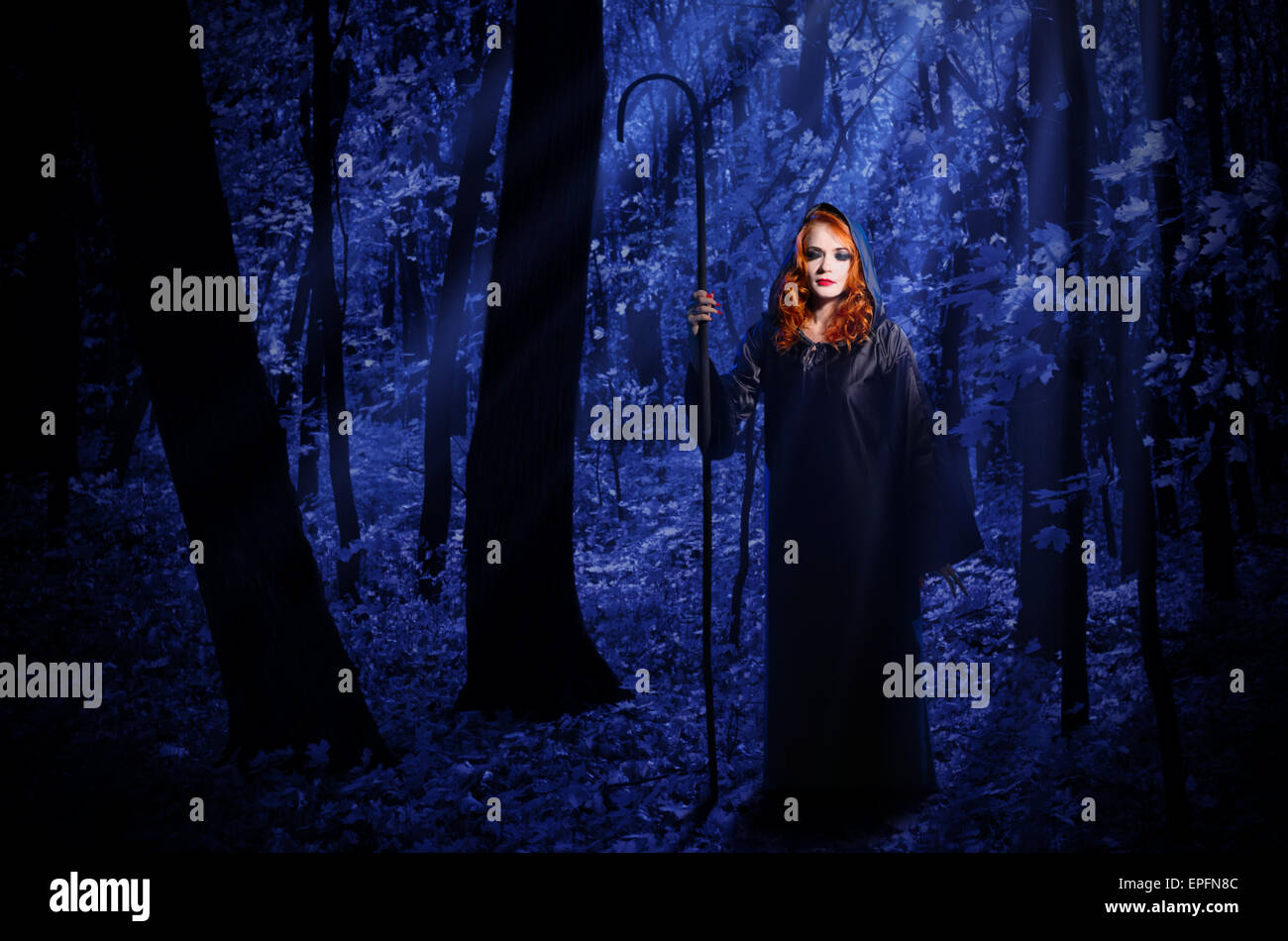 Jeune sorcière dans la nuit dans la forêt clair de lune Banque D'Images