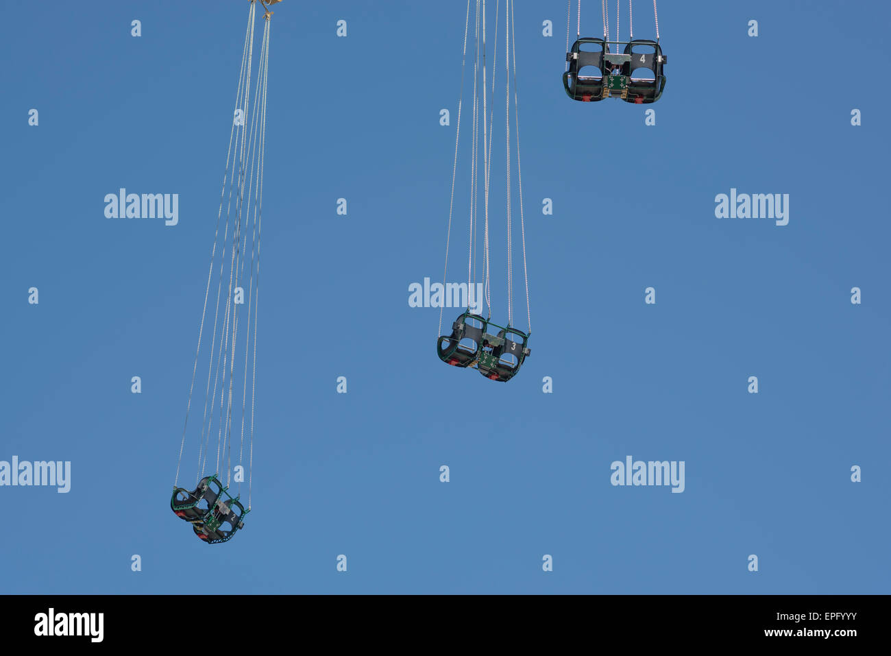 Chaises vides, trois ensembles de chaises dangle de la célèbre attraction Prater Turm dans le parc d'attractions Prater de Vienne, en Autriche. Banque D'Images