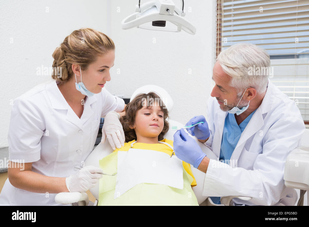 Pédodontiste montrant petit garçon comment brosser les dents Banque D'Images