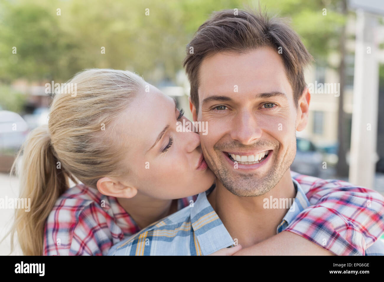 Jeune femme de la hanche copain baiser sur la joue Banque D'Images