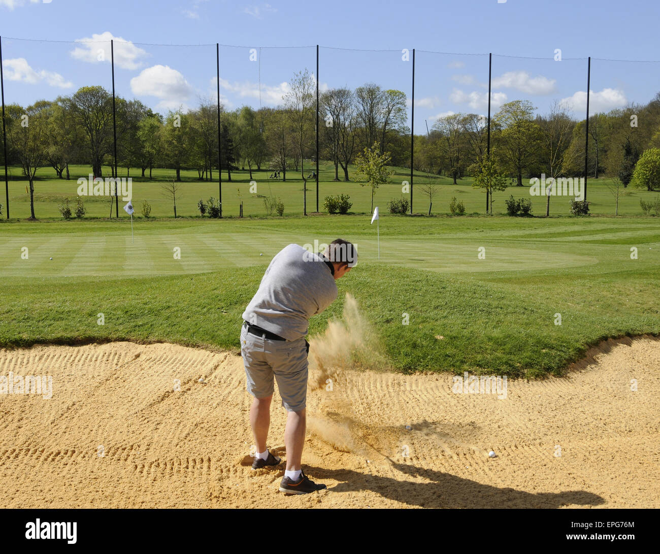 Male Golfer jouer à partir d'un Bunker à la pratique la masse à Sundridge Park Golf Club Bromley Kent England Banque D'Images