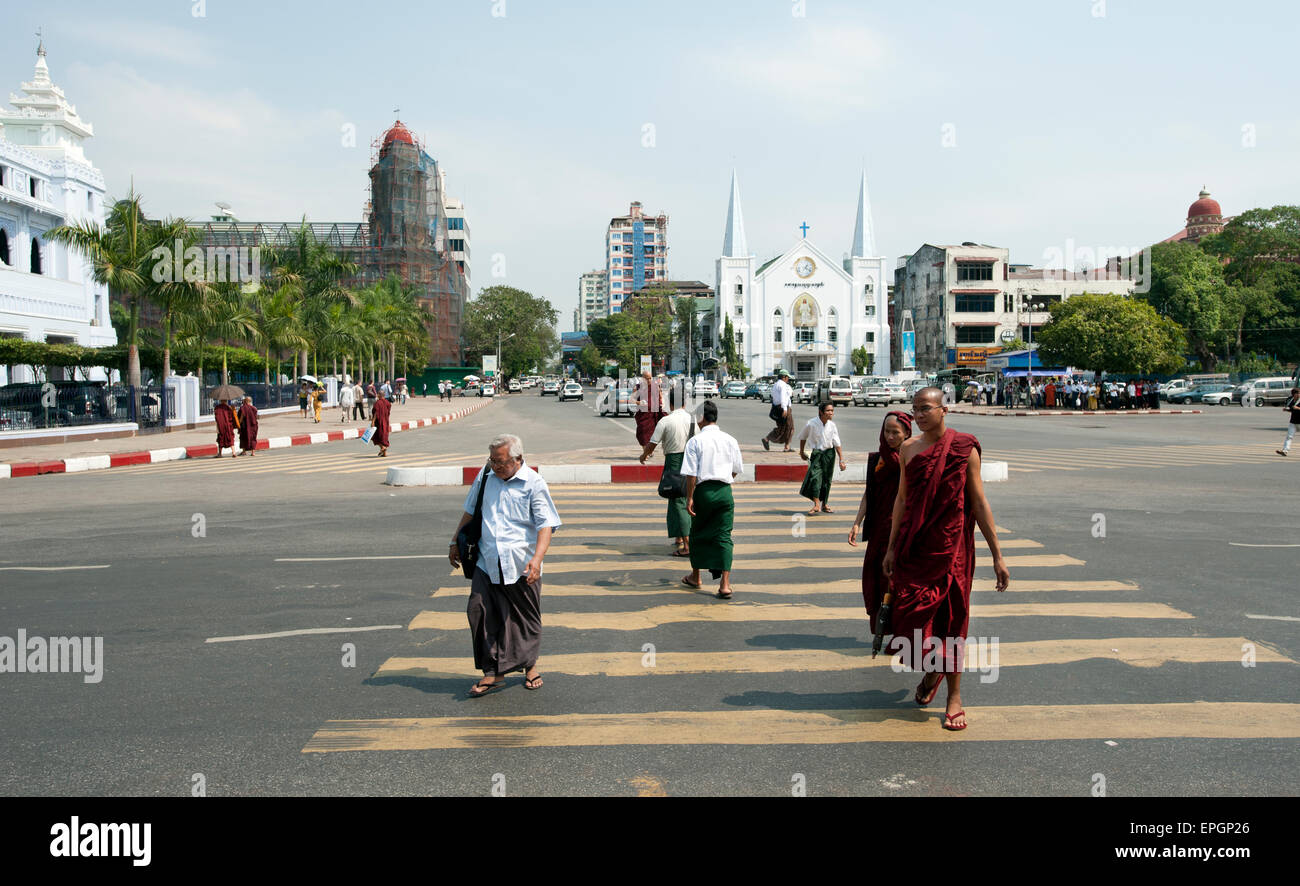 Les moines et les gens traversent la route au centre-ville de Yangon Myanmar Banque D'Images