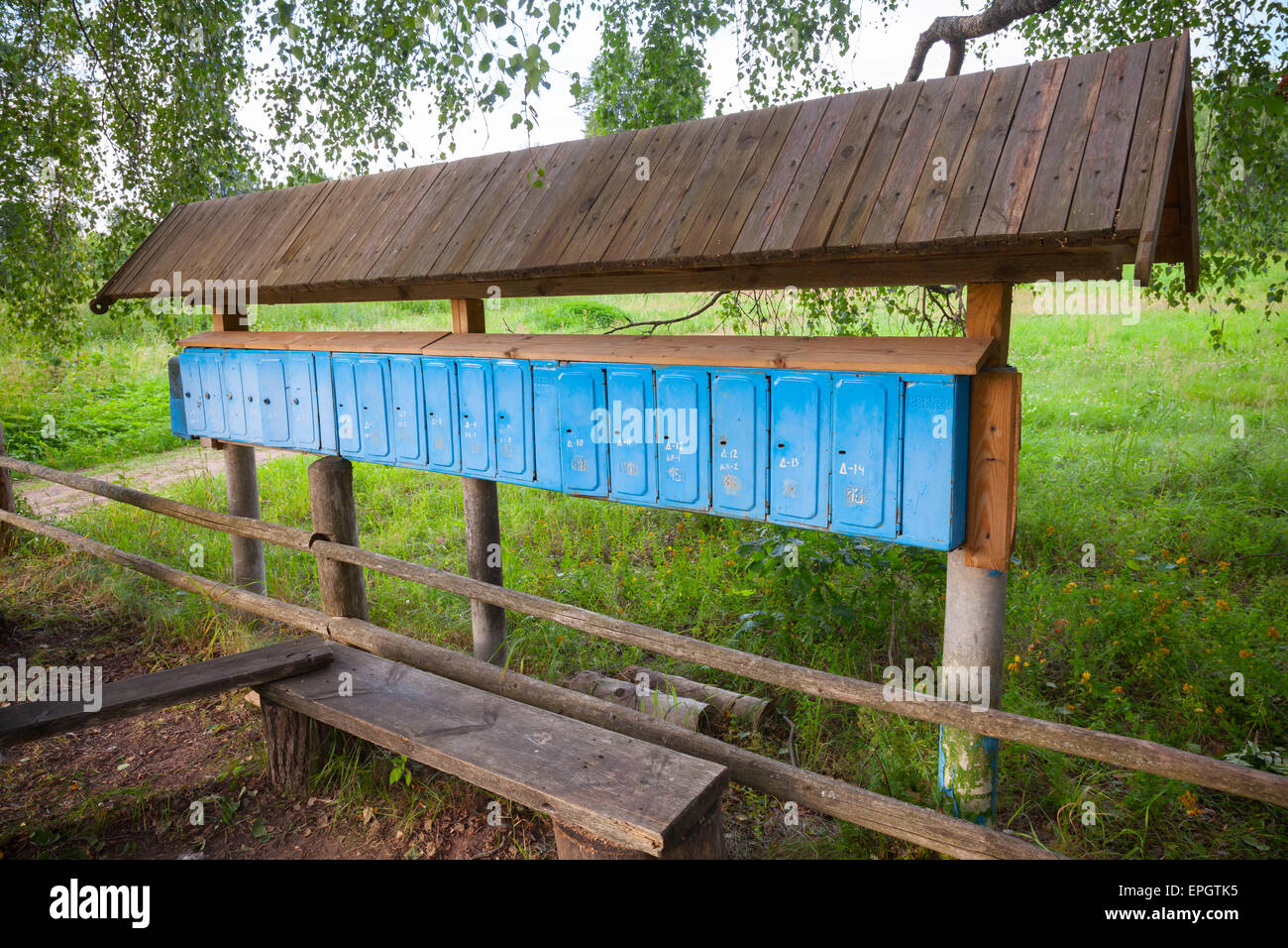 Vieilles boîtes aux lettres bleu rouillé dans une rangée, petit village russe Banque D'Images