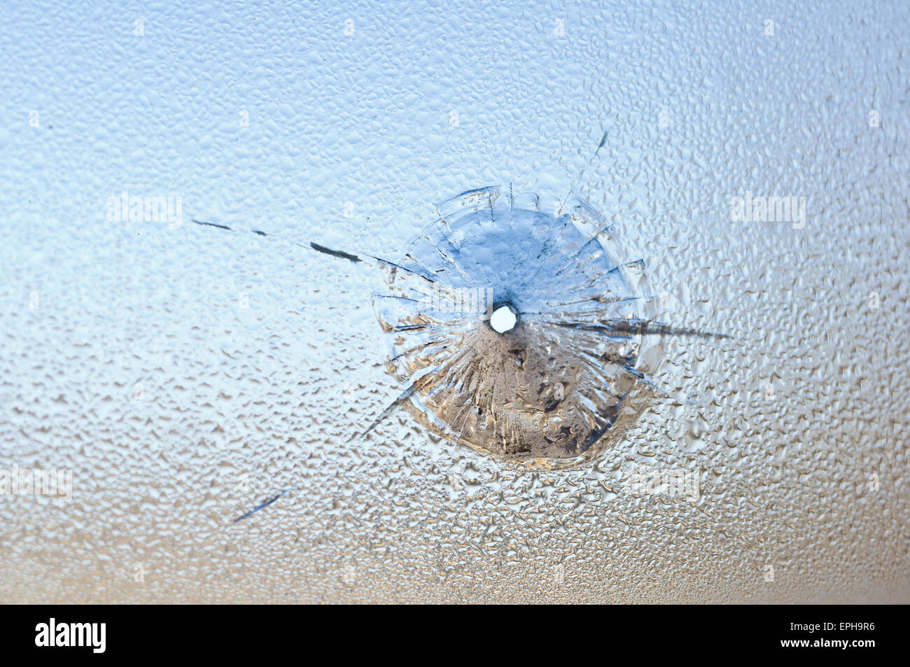 Bullet Aperture dans le verre humide, le verre brisé. Photo conceptuelle - danger Banque D'Images