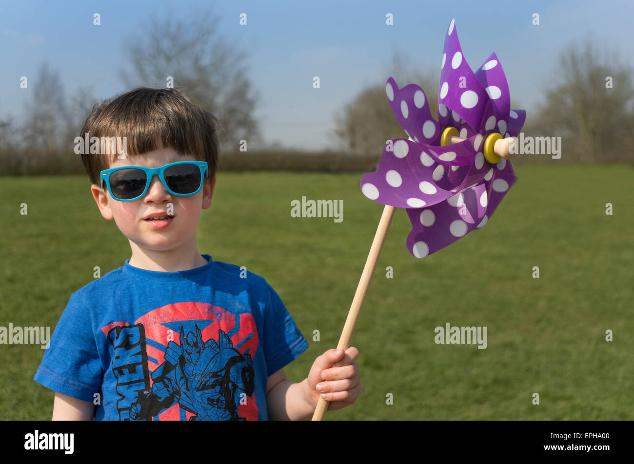 Petit garçon aux lunettes bleues et un moulin à vent avec Polka Dot's Banque D'Images