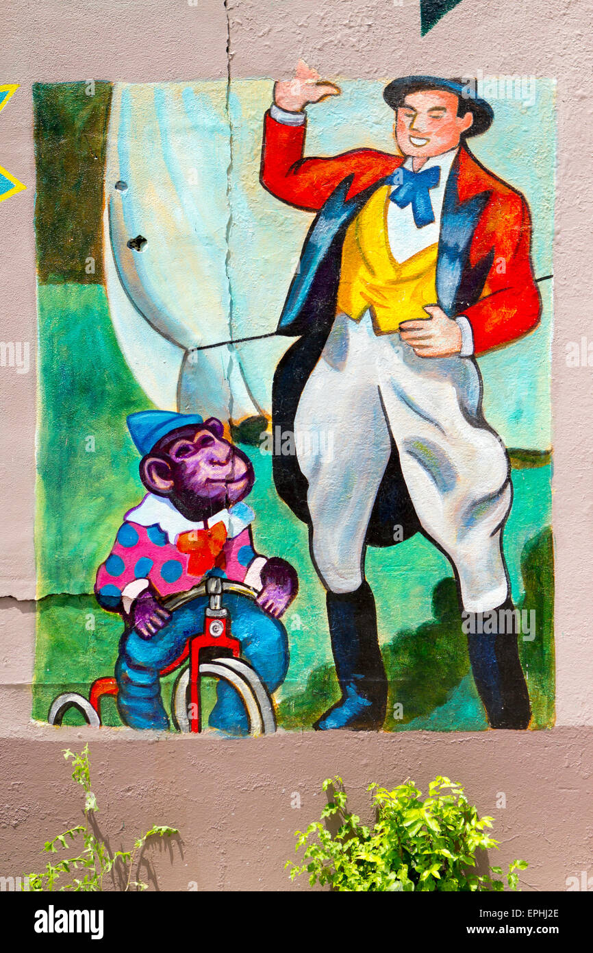L'art de mur de circus ringmaster avec singe sur un tricycle Banque D'Images