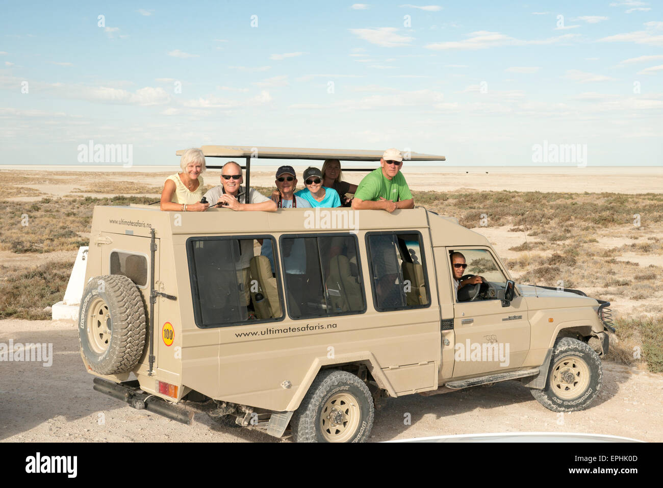 L'Afrique, la Namibie. Etosha National Park. Groupe de touristes posant et souriant pour l'appareil photo. Banque D'Images