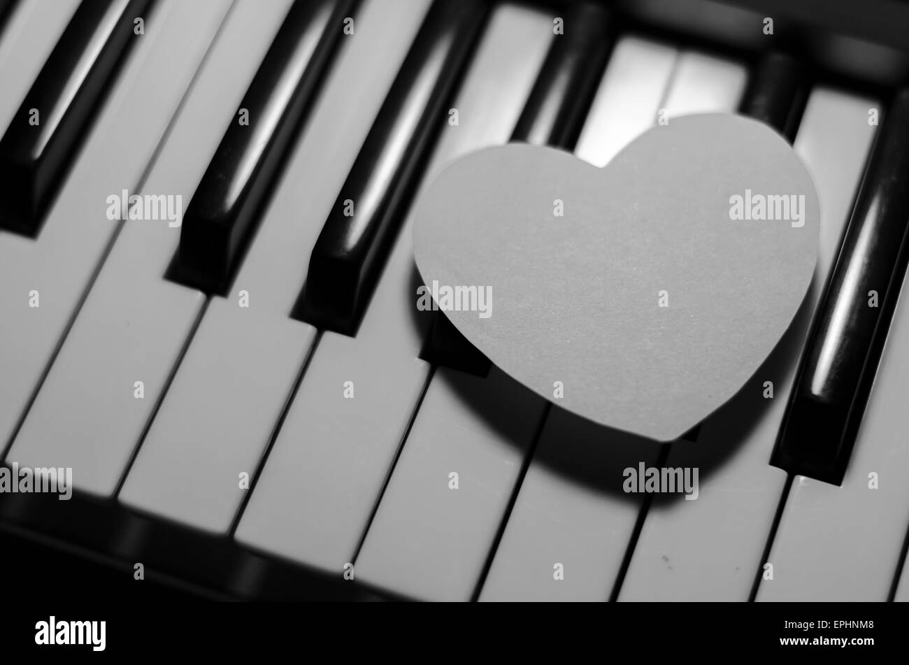 Coeur de papier sur piano clavier noir et blanc couleur Banque D'Images