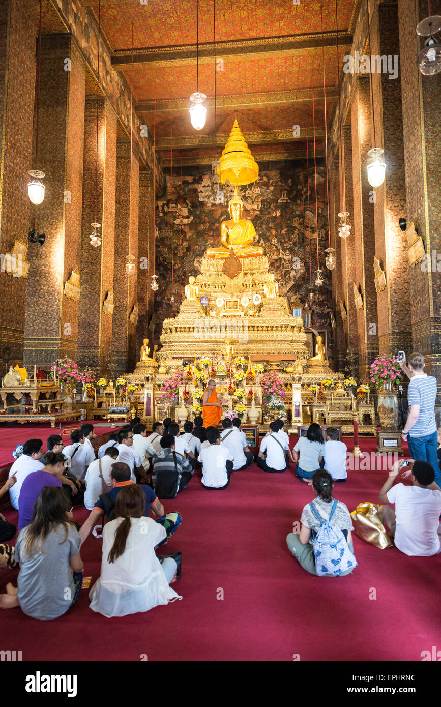 Le moine bouddhiste parlant aux croyants en face de Bouddha assis dans le temple de Wat Pho, Phra Phuttha Thewa, Phra Ubosoth Patimakon Banque D'Images