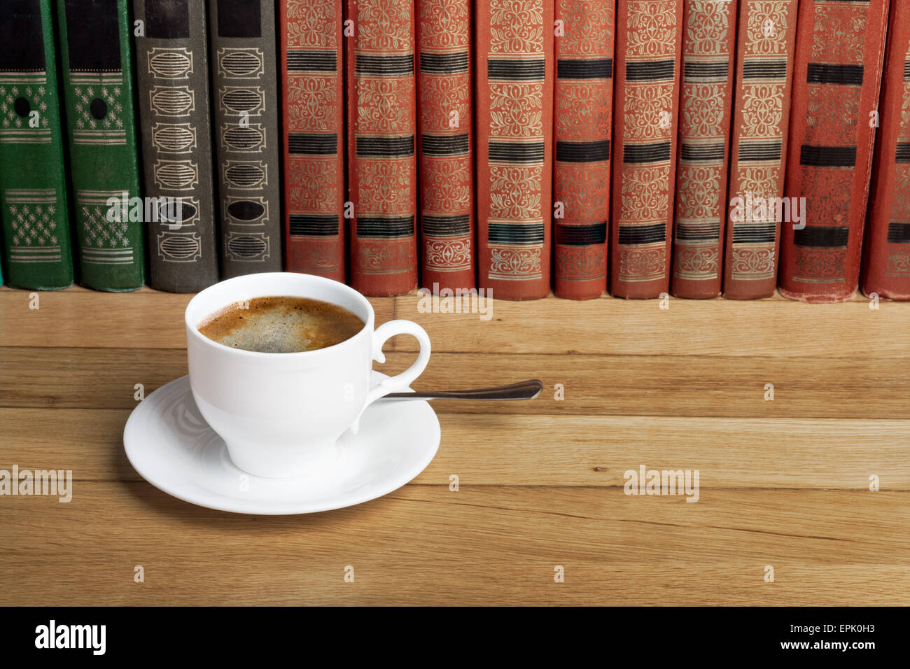 Tasse de café frais sur la table en bois et une pile de livres à lire Banque D'Images