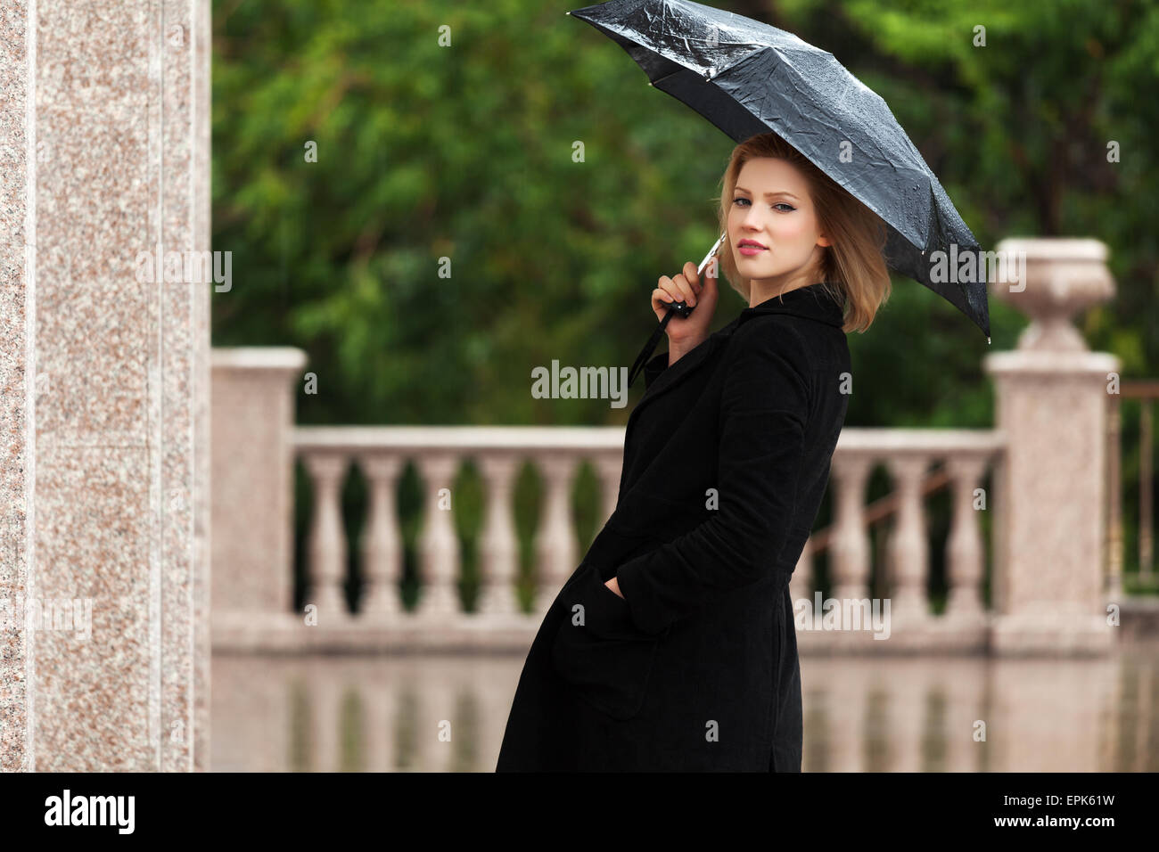 Femme heureuse avec parapluie sous la pluie Photo Stock - Alamy