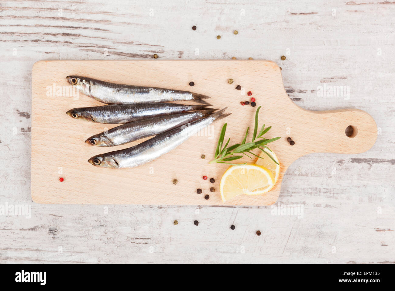 De délicieuses sardines fraîches sur cuisine en bois avec du citron, romarin et poivre colorés sur fond de bois. Culinary Banque D'Images