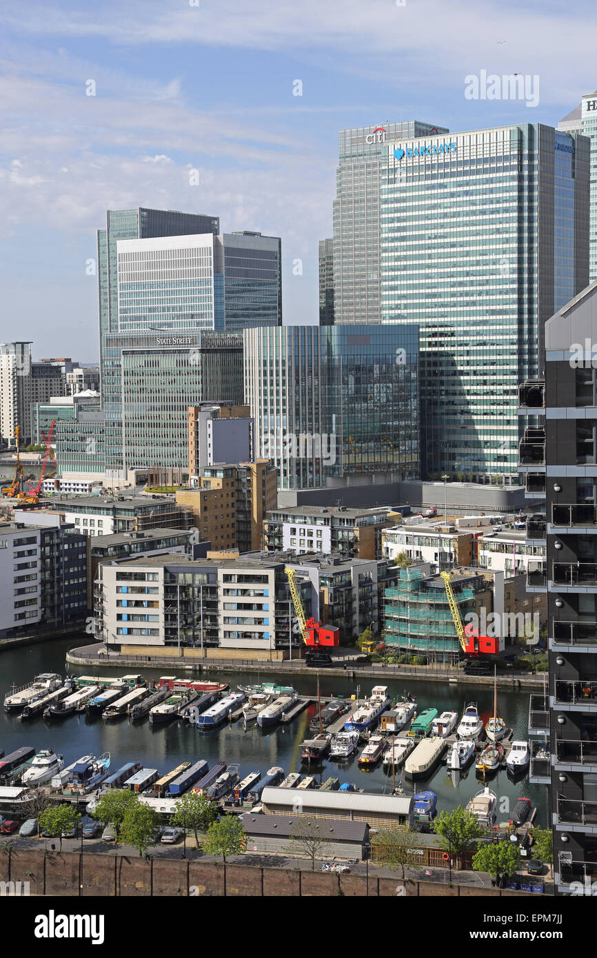 Le quartier de Canary Wharf de Londres vue de l'est montrant étroit traditionnels bateaux amarrés à quai dans l'avant-plan de peuplier Banque D'Images