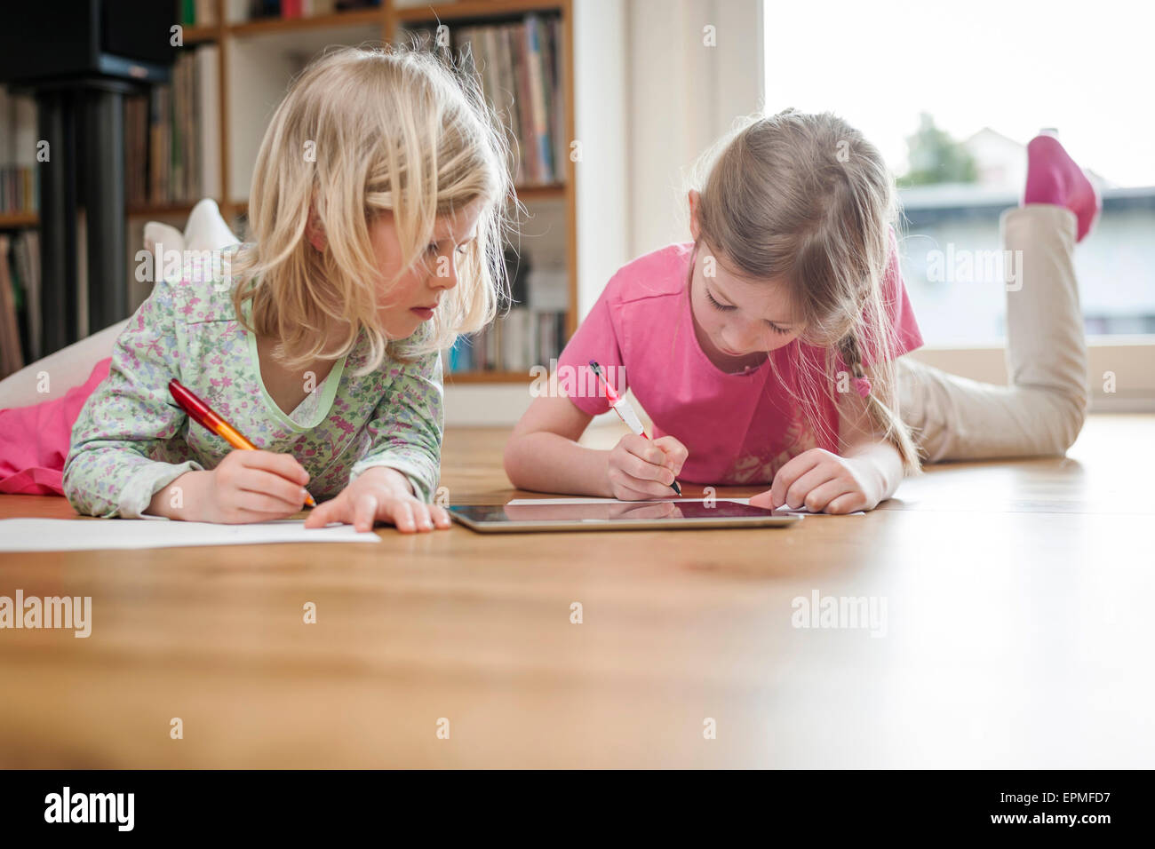 Deux soeurs avec tablette numérique et de feuilles de papier sur marbre Banque D'Images